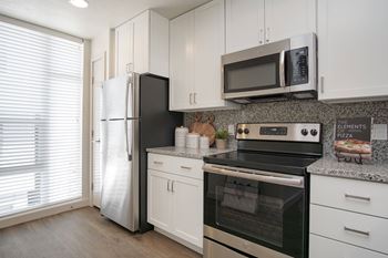 A modern kitchen with stainless steel appliances and white cabinets.